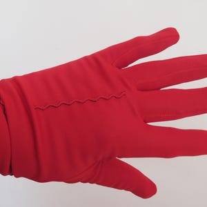 May include: A pair of red gloves with a zig-zag stitch detail along the back of the hand.
