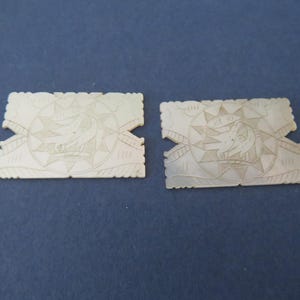 Peut inclure: Deux pièces rectangulaires en nacre blanche avec des sculptures complexes d'une étoile et d'un oiseau à l'intérieur de l'étoile. Les pièces sont assemblées pour former un rectangle plus grand.