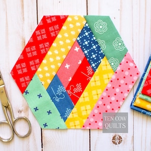 May include: A colorful, hexagonal quilt block with diagonal stripes of red, yellow, pink, blue, and green fabrics. Each fabric has a unique pattern, including floral, polka dots, and cross designs. The text "TEN COW QUILTS" is visible.