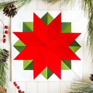 May include: A red and green Christmas quilt block with a star design. The star is made of red fabric and the background is white with green fabric around the star.
