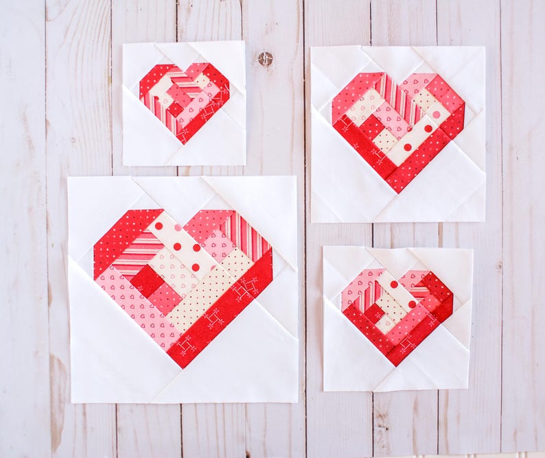 May include: Three white fabric squares with red and pink patchwork hearts in different sizes. The hearts are made of various patterned fabrics, including stripes, polka dots, and hearts.