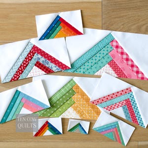 May include: A selection of handmade quilt blocks with white fabric and colourful, patterned accents. The blocks have a chevron design with colours like red, blue, green, and orange. The text "TEN COW QUILTS" is visible.