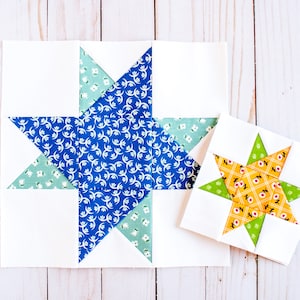 May include: Two fabric patchwork star blocks, one larger than the other. The larger block features a blue and green star on a white background. The smaller block features a yellow and green star on a white background.