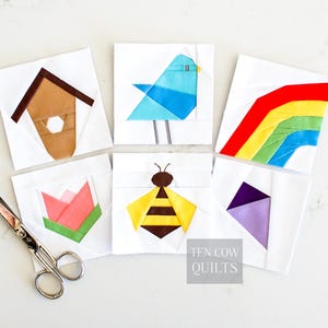 Könnte beinhalten: Sechs weiße Stoffquadrate mit farbenfrohen Patchwork-Designs. Die Designs umfassen ein Vogelhaus, einen blauen Vogel, einen Regenbogen, eine Tulpe, eine Biene und eine abstrakte lila Form. Eine Schere befindet sich in der unteren linken Ecke. Der Text "TEN COW QUILTS" befindet sich unten rechts.