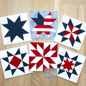 Puede incluir: Seis bloques cuadrados de tela para acolchado con diseños de estrellas en rojo, blanco y azul marino. Los bloques están dispuestos sobre una superficie de madera clara, mostrando una variedad de patrones de estrellas.