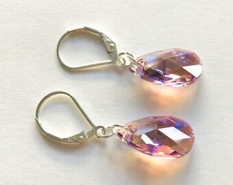 May include: A pair of silver dangle earrings with teardrop-shaped purple crystals.