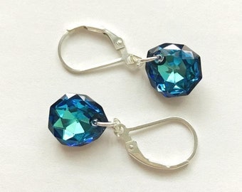 May include: A pair of silver dangle earrings with blue crystal teardrop-shaped charms.