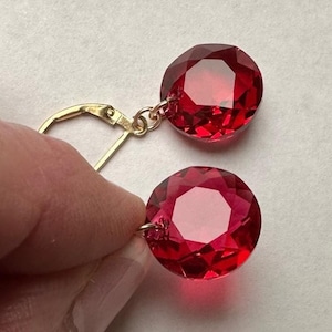 May include: A pair of red crystal earrings with gold-toned leverback closures.
