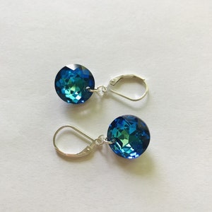 May include: A pair of silver dangle earrings with round blue crystal stones.