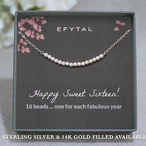 May include: A white gift box with a silver and gold pearl necklace inside. The box has a black background with white text that reads "EFYTAL", "Happy Sweet Sixteen!" and "16 beads... one for each fabulous year". The bottom of the box reads "STERLING SILVER & 14K GOLD FILLED AVAILABLE".