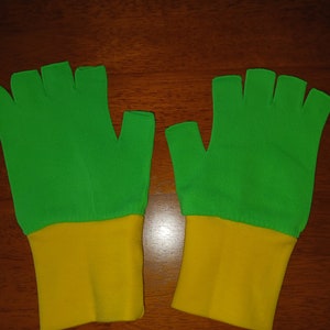 May include: A pair of fingerless gloves with a green top and a yellow bottom.