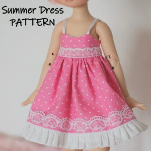 May include: A pink polka dot summer dress with white lace trim and a white ruffle at the hem. The dress is designed for a doll.