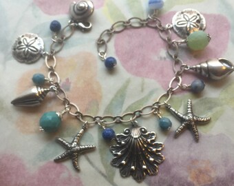 Br-108 Silver Sealife Charm Bracelet. Seashell, starfish, sand dollar charms. Lapis lazuli stones. Green blue Czech glass beads. Free Ship.