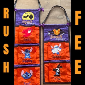 May include: Two Halloween-themed fabric organizers with black straps and purple bows. Each has a purple top with a Halloween design and orange pockets featuring Disney characters. Text includes "Halloween High Seas" and character names.