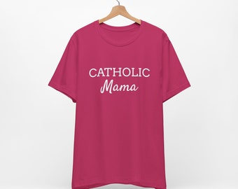 May include: A pink t-shirt with the text "CATHOLIC Mama" in white.