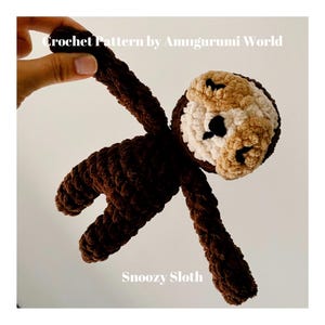May include: A brown crocheted sloth amigurumi toy with a beige face and black eyes. The toy is hanging in the air with its arms and legs outstretched. The text "Snoozy Sloth" is written below the toy.