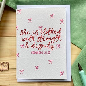 Christelijke kaart - Ze is gekleed met kracht en waardigheid - Spreuken 31:25, handgeschreven met strikken
