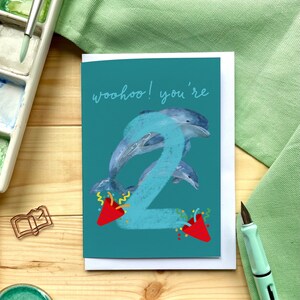 Deuxième carte d'anniversaire « Woohoo ! Vous avez 2 ans » avec des dauphins, des canons à confettis et un grand numéro deux