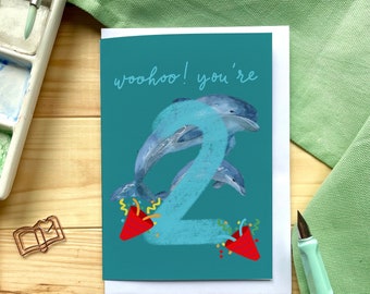 Second birthday card "Woohoo! You're 2" with dolphins, confetti canons and big number two