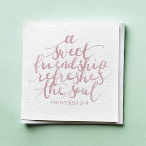 Puede incluir: Una tarjeta de felicitación cuadrada con la cita "a sweet friendship refreshes the soul" en caligrafía rosa. El texto "PROVERBIOS 27:9" está debajo de la cita. La tarjeta está sobre un fondo verde claro.