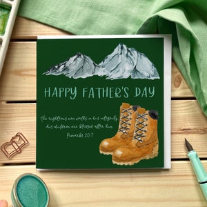 Tarjeta del Día del Padre cristiano con montañas, botas para caminar y un versículo de las Escrituras de la Biblia