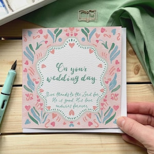 Tarjeta de boda cristiana en rosa pastel con la frase "en el día de tu boda" y un versículo bíblico.