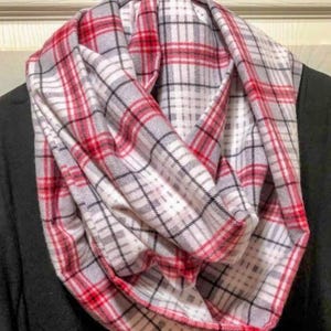 May include: A red and white plaid infinity scarf. The scarf is made of a soft, comfortable fabric and is perfect for keeping warm in the winter.