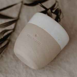 May include: A white and beige ceramic mug with the text 'CIAO KAKAO' and a heart symbol on the side.