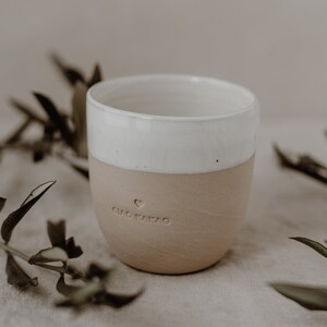 May include: A white and beige ceramic mug with a heart and the text 'Ciao Kakao' on the side.