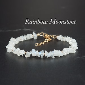 May include: A delicate bracelet made with small, irregular pieces of rainbow moonstone, strung on a gold chain. The bracelet has a small gold clasp for easy fastening.