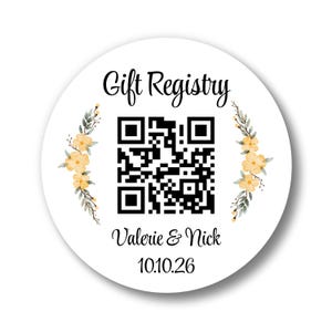 May include: A white, circular sticker with the words "Gift Registry" in elegant script. A QR code is in the center, with the names "Valerie & Nick" and the date "10.10.26" below. Floral accents in yellow and green adorn the sides.