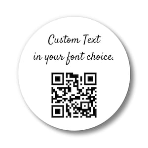 May include: A white, circular sticker with the text "Custom Text in your font choice." in black script. A black and white QR code is centered below the text. The sticker has a slight shadow.