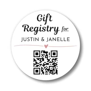 May include: A circular white sticker featuring the black text Gift Registry for JUSTIN & JANELLE. Below the names is a thin horizontal pink line with a small pink heart in the center. A black and white QR code is positioned at the bottom.