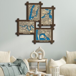 May include: A wooden wall art piece with four framed maps of different cities. The maps are of New York, Boston, London, and San Diego. The frames are brown and the maps are blue and white.