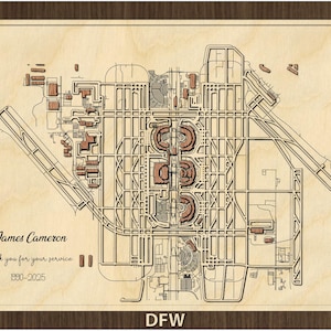 May include: A detailed wooden map of DFW airport, framed in dark brown. The map features intricate laser-cut details of runways, terminals, and surrounding structures. Text includes "James Cameron", "Thank you for your service", and the years "1990-2025".