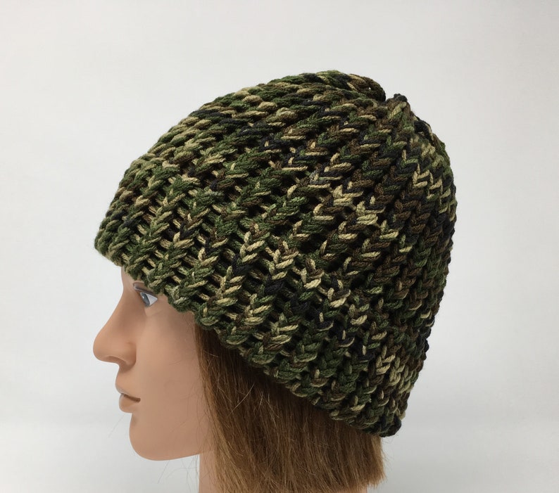 May include: A green, brown, and black camouflage knit beanie hat.