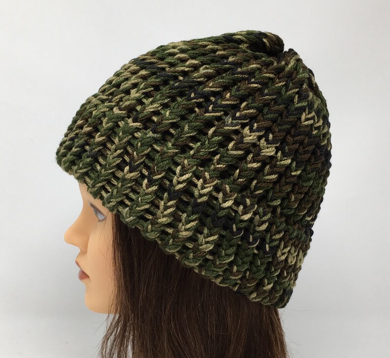 May include: A green, brown, and black camouflage knit beanie hat.