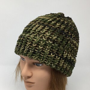 May include: A green, brown, and black camouflage knit beanie hat.