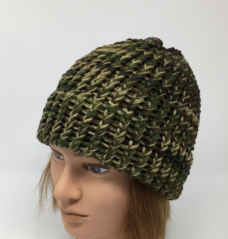 May include: A green, brown, and black camouflage knit beanie hat.