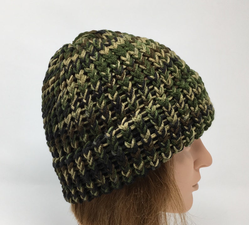 May include: A green, brown, and black camouflage knit beanie hat.