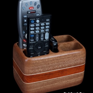 Hardwood remote control holder holds four remotes and smartphone.