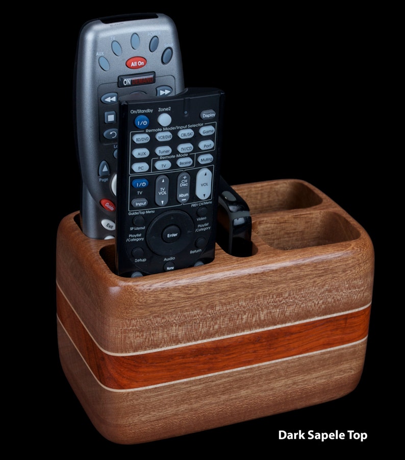 Hardwood remote control holder holds four remotes and smartphone.