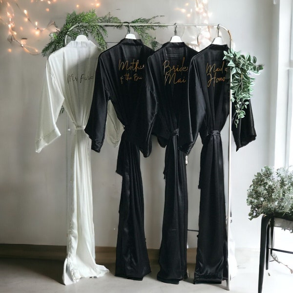 Long black personalized satin bridesmaid robes with front and back gold text. Custom gifts for Mother of the Bride, Groom and Bridal party.