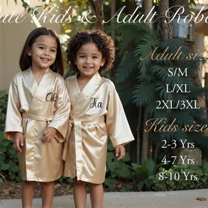 two little girls in gold robes standing next to each other