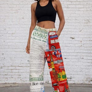May include: A black ribbed vest top and wide-leg trousers featuring a split design. The left side is cream with black printed text and green shamrock motifs. The right side is red with a London bus, Union Jack flag, and various city landmarks.
