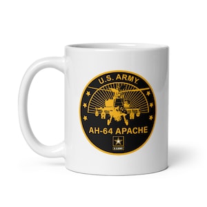 May include: White ceramic coffee mug with a black and gold graphic of a U.S. Army AH-64 Apache helicopter. The graphic includes the text "U.S. ARMY" and "AH-64 APACHE".