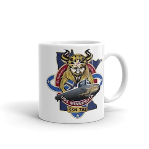 Puede incluir: Taza de cerámica blanca con un gráfico colorido de un submarino, un vikingo y el texto "USS MINNESOTA SSN 783".