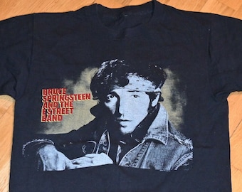 May include: Black t-shirt with a vintage image of Bruce Springsteen and the E Street Band. The image is in black and white and shows Springsteen looking directly at the viewer.