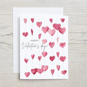 May include: A white card with a pink watercolor heart garland and the text "Happy Valentine's Day!"