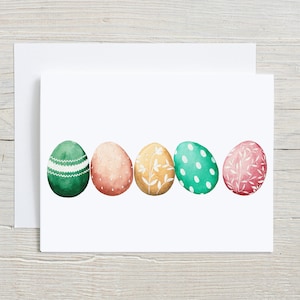 May include: Five Easter eggs in a row, each with a different pattern. The eggs are green, pink, yellow, green, and pink. The patterns include polka dots, stripes, flowers, and leaves.